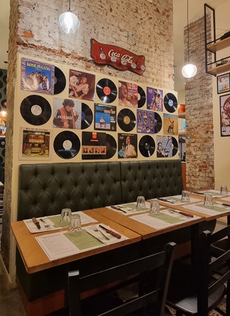 Interni della pizzeria Glory POP a Milano in zona Wagner, vinili appesi alle pareti, stile vintage anni '80