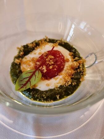Piccola tazza in vetro trasparente che contiene pesto di basilico, burrata, pomodoro confit e tarallo sbriciolato come benvenuto dello chef Norman Berini Locanda Le Vie del Borgo a Toceno