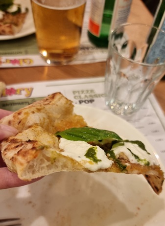 Trancio di pizza POP con stracciatella, basilico, olio al limone, crema di basilico, pomodirini gialli, alici e tarallo sbriciolato di Glroy POP pizzeria a Milano